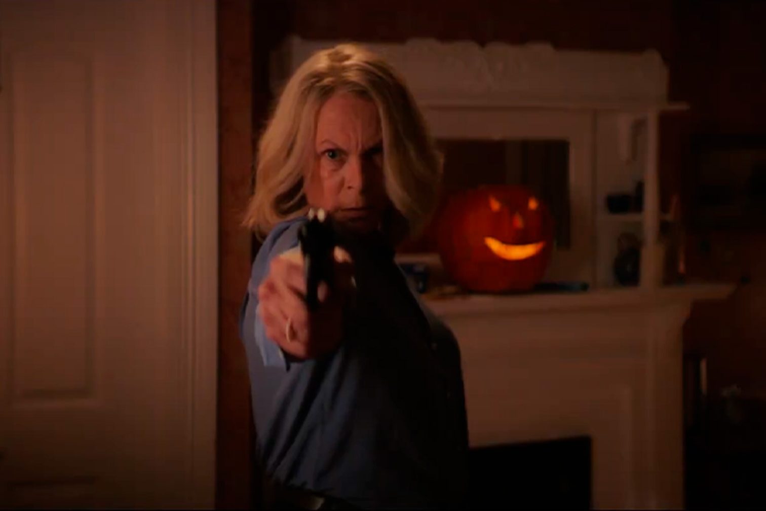 Jamie Lee Curtis segura uma arma em uma cena de Halloween Ends.