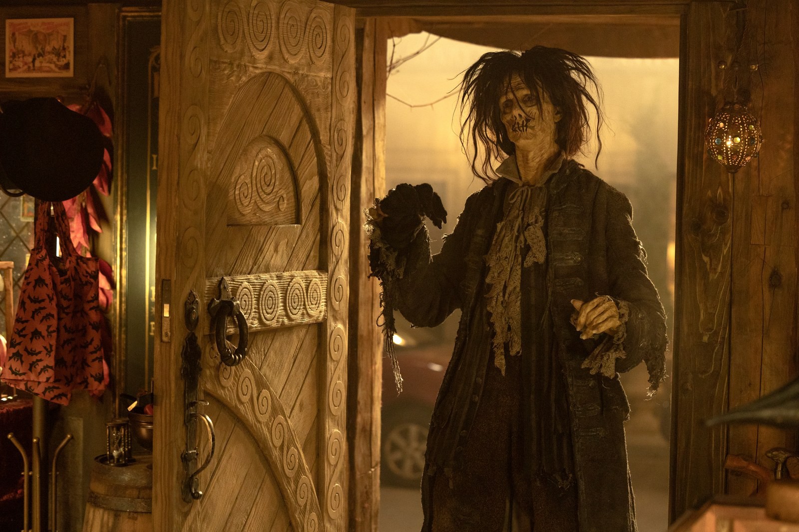 Doug Jones como Billy Butcherson zumbificado abre uma porta em uma cena de Hocus Pocus 2.
