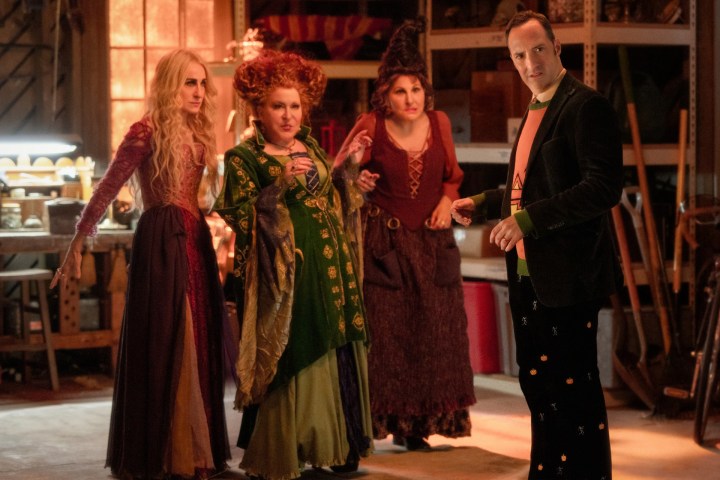 Sarah Jessica Parker, Bette Midler, and Kathy Najimy as the Sanderson sisters stand near Tony Hale in a scene from Hocus Pocus 2.