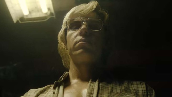 Evan Peters as Jeffrey Dahmer looking down at something ominously in Dahmer - Monster: The Jeffrey Dahmer Story.