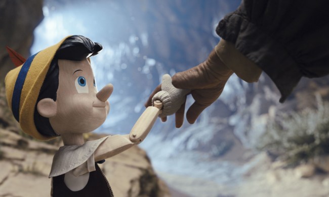 Pinocchio holds Geppetto's hand in a scene from the 2022 live-action film.