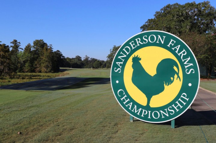 Sanderson Farms Championship sign on an open green golf course.