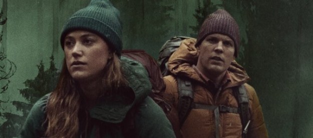 Maika Monroe and Jake Lacy wander through a forst in a promotional image from Significant Other.