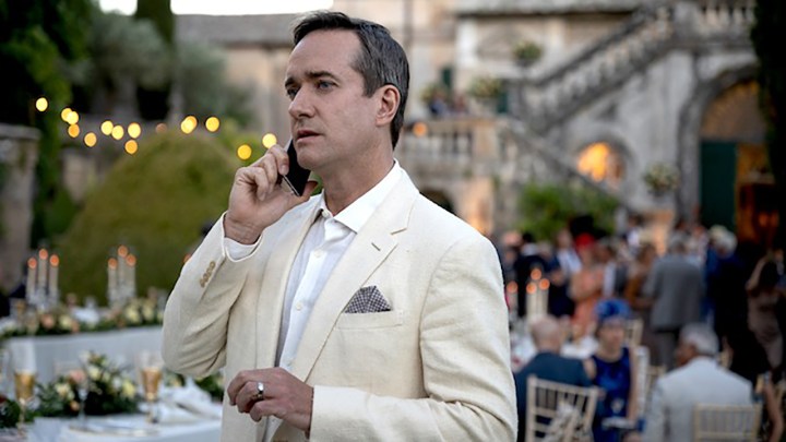 Tom from Succession in a white suit, on the phone.