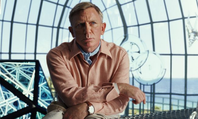 Daniel Craig stands and ponders in a scene from Glass Onion: A Knives Out Mystery.