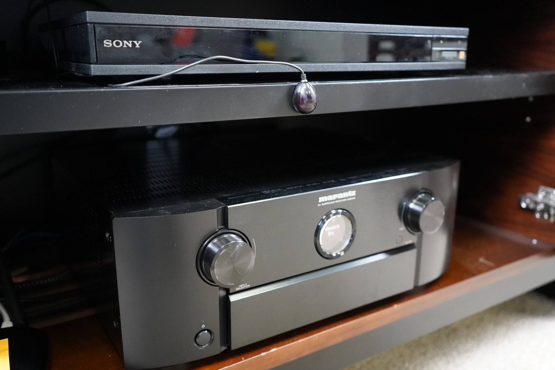 A Marantz A/V receiver and Sony 4K Blu-ray player controlled with an IR blaster from an Amazon Fire TV Omni QLED TV.