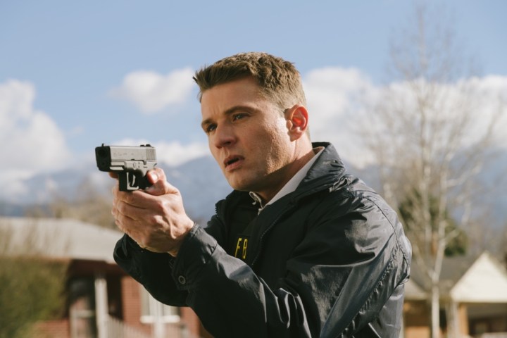 Ryan Phillippe aponta uma arma em uma cena de American Murderer.