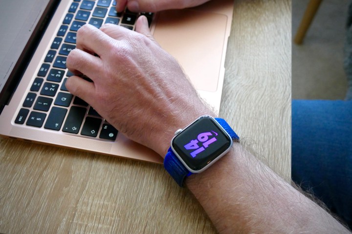 Homme portant l’Apple Watch SE 2 et tapant sur un MacBook.