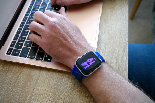 Man wearing the Apple Watch SE 2 and typing on a MacBook.