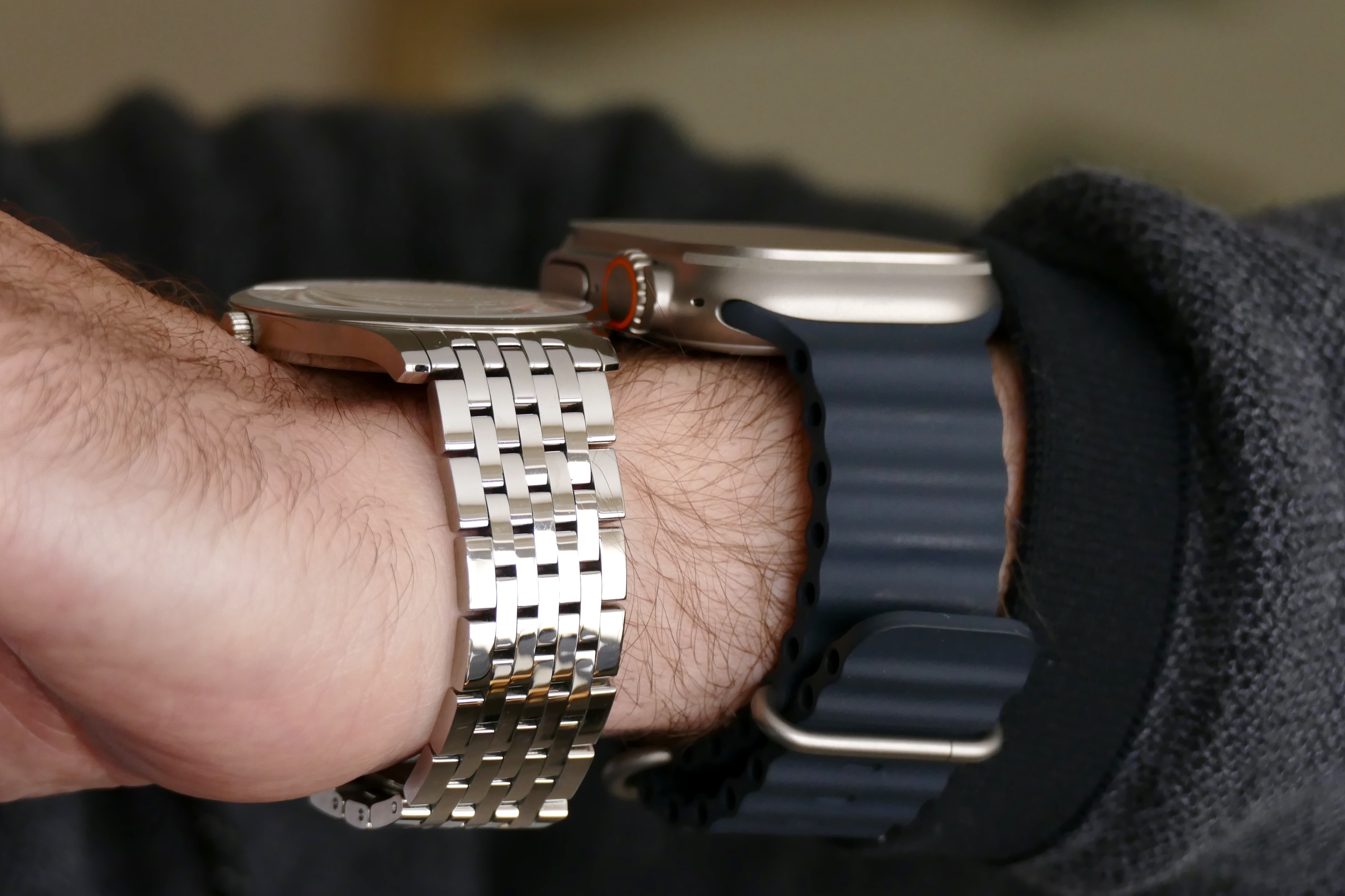 The Apple Watch Ultra with the Tissot Tradition seen from the side on a wrist.