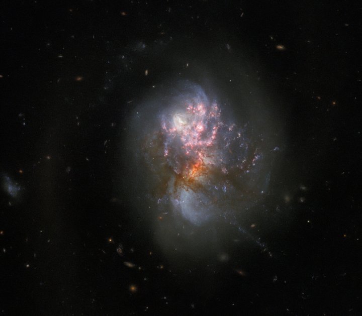 Esta imagem do Telescópio Espacial Hubble da NASA/ESA mostra o IC 1623. Combina dados dos instrumentos ACS e WFC3 do Hubble, dá uma visão familiar da luz visível dessas galáxias em colisão, onde os centros das galáxias individuais são mais obscurecidos pela poeira escura.