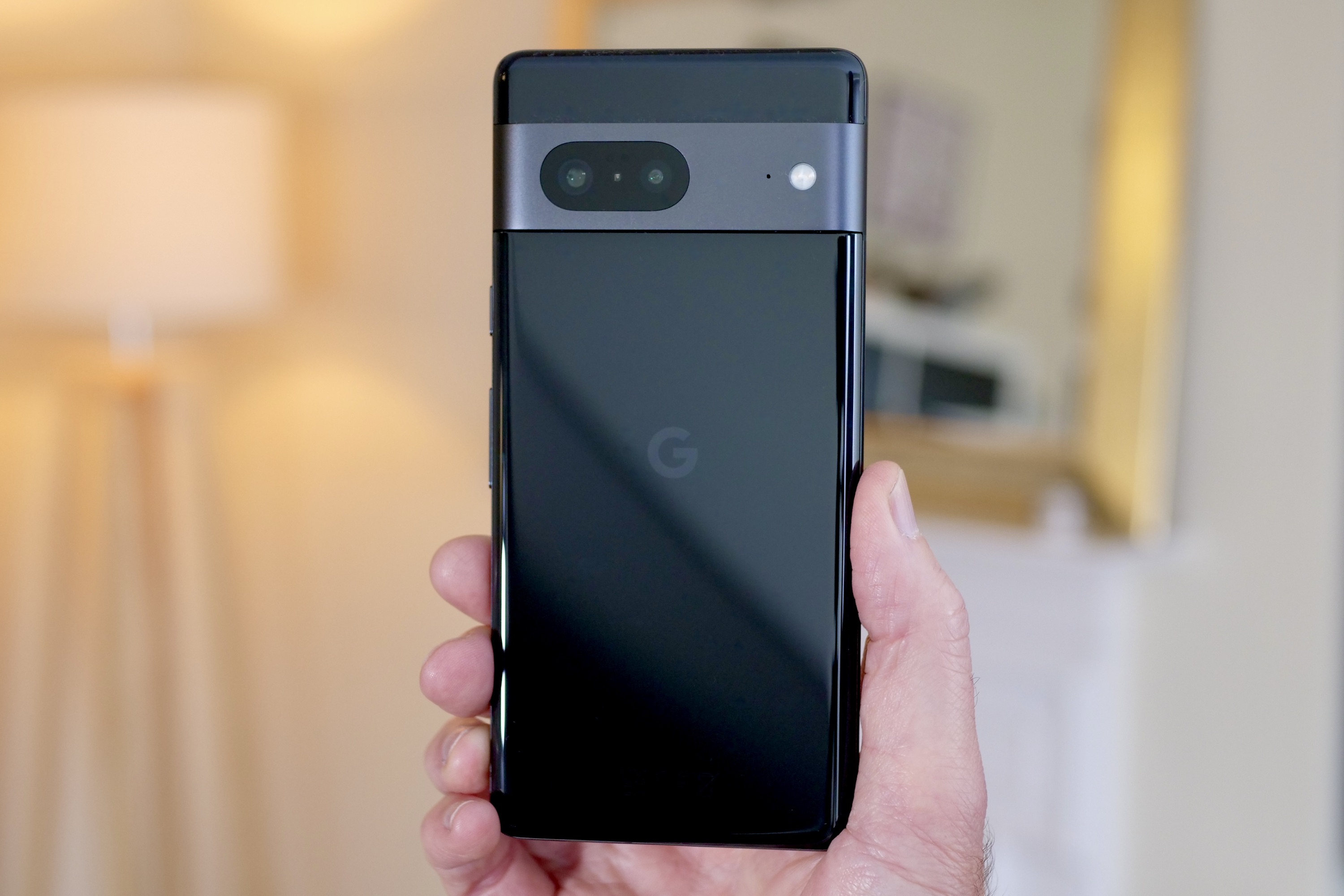 A parte traseira do Google Pixel 7, segurada pela mão de um homem.