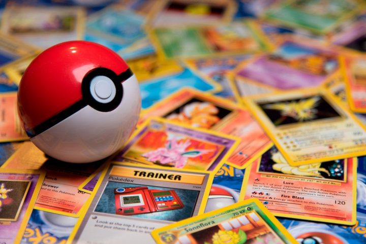 Pokeball on accumulation of Pokemon Trading Cards in room.