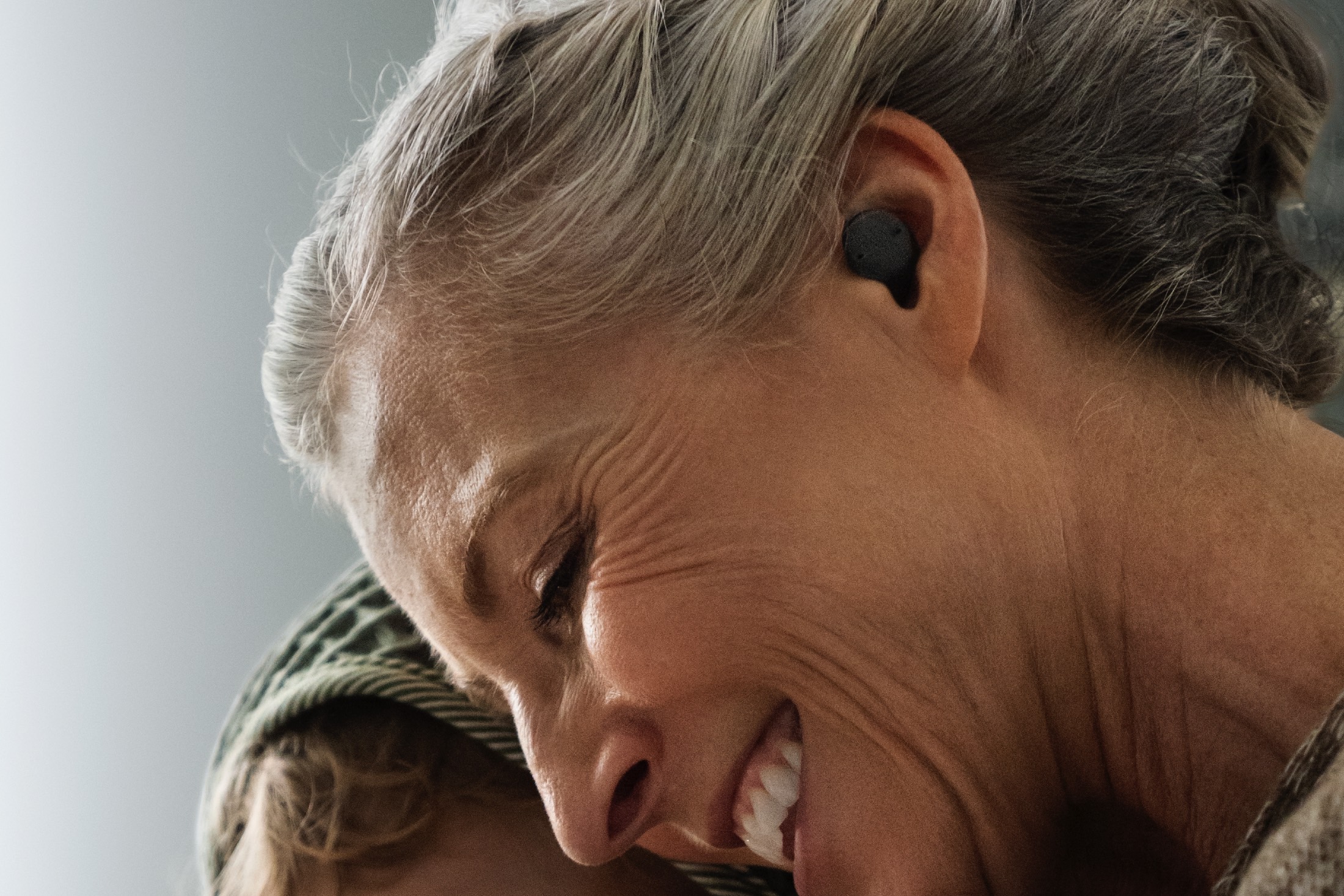 Woman wearing Sony CRE-E10 OTC hearing aids.