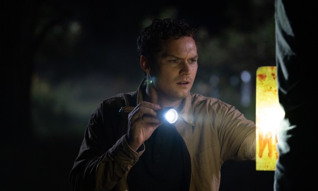 Finn Jones holds a flashlight in a scene from The Vistor.