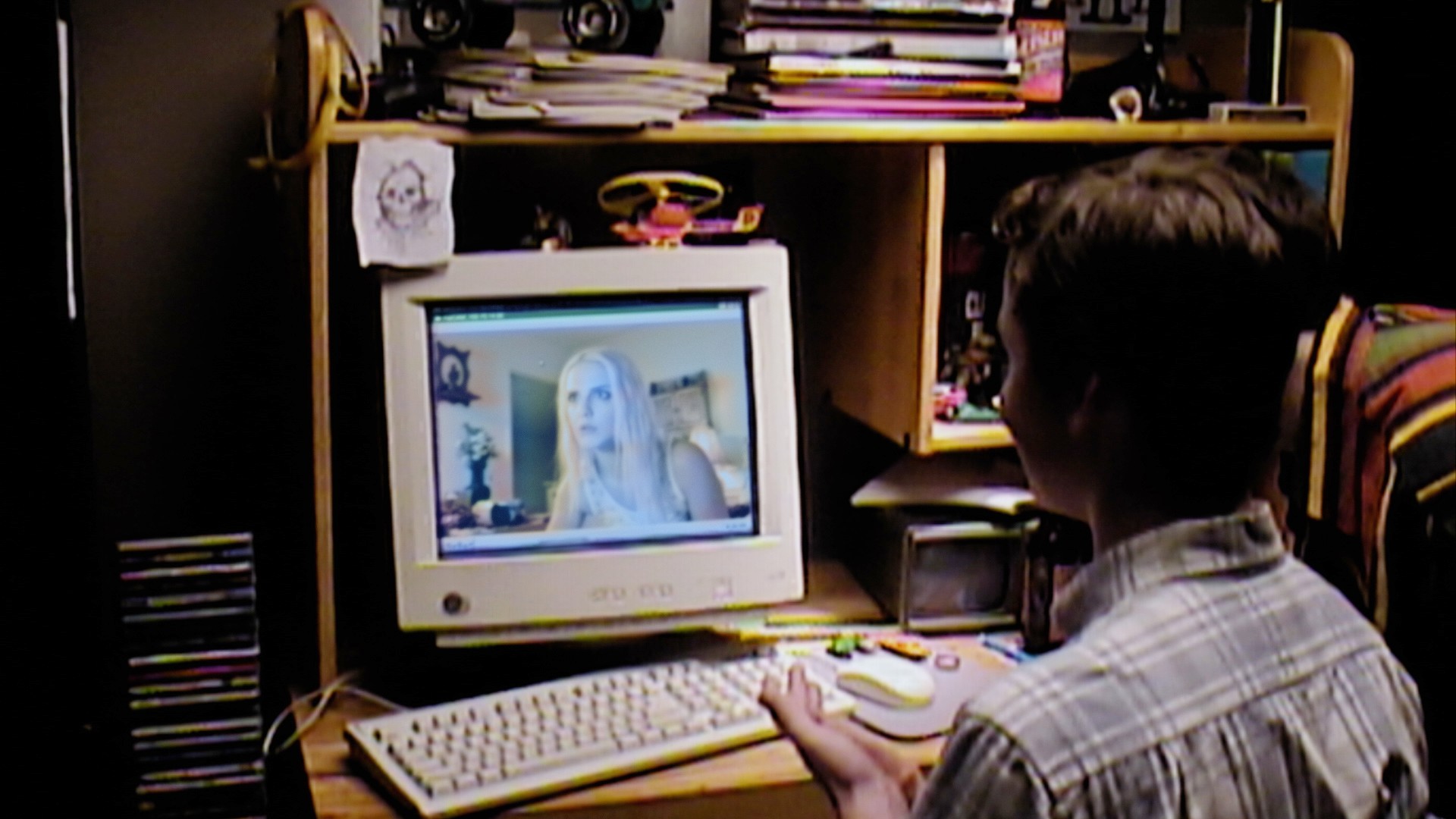 A male teenager sits at a computer in V/H/S/99.