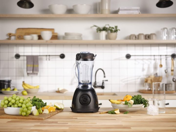 Vitamix One sits on kitchen counter next to fruits and vegetables.