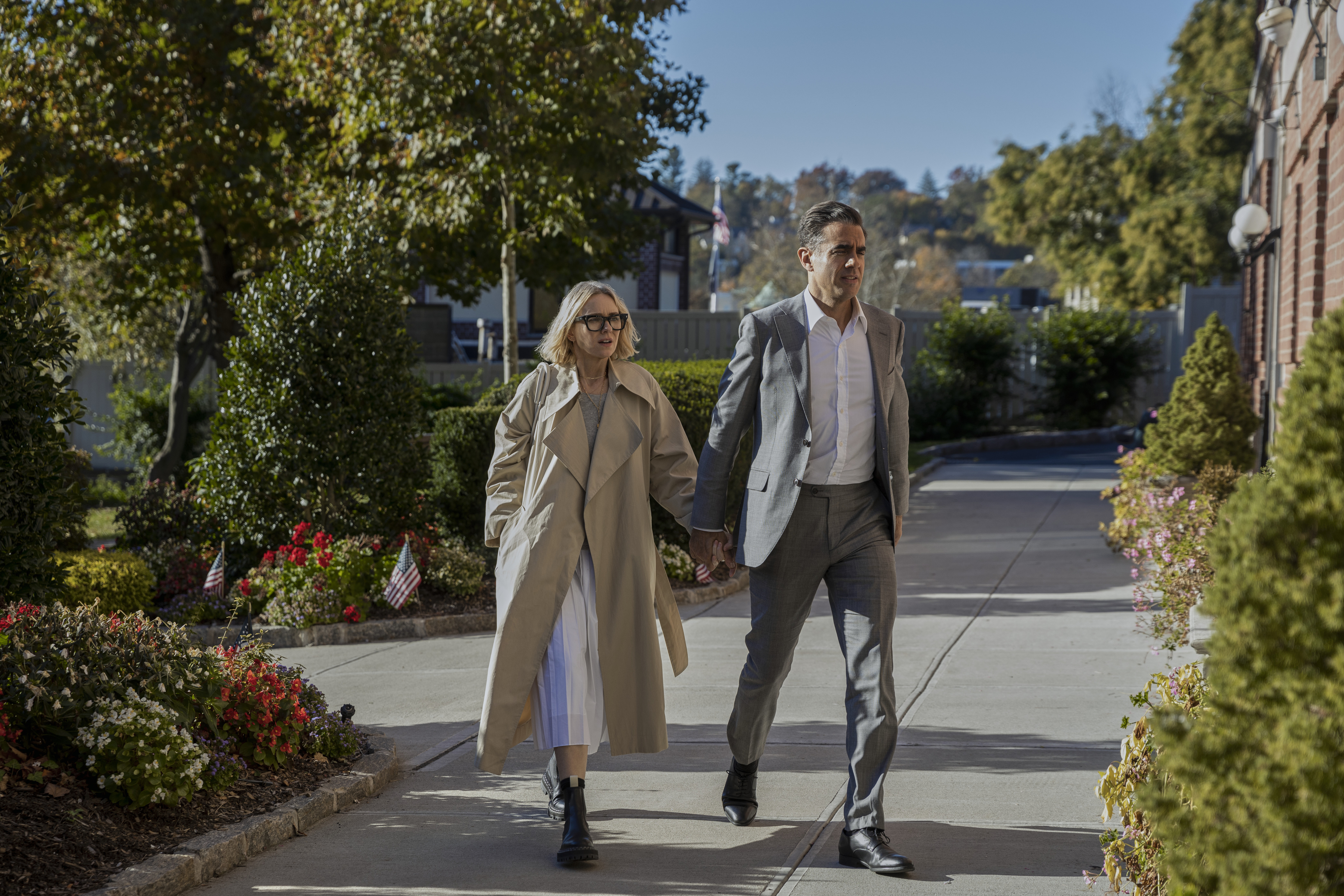 Naomi Watts and Bobby Cannavale walk in unison in a scene from Netflix's The Watcher.
