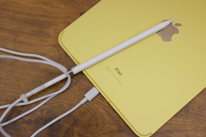 The iPad (2022) with an Apple Pencil plugged into it using a USB-C cable and adapter.