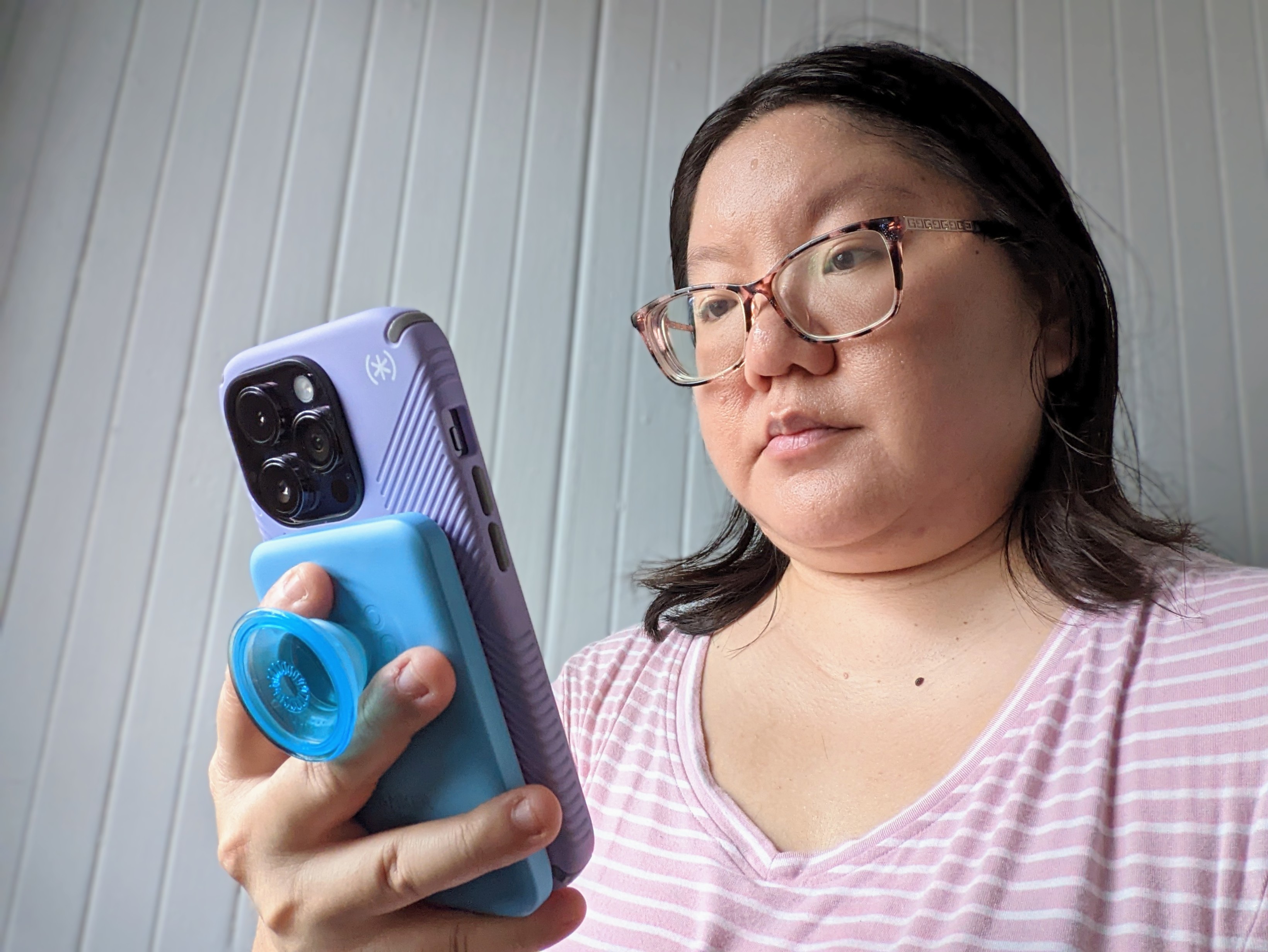 Christine Romero-Chan usa seu iPhone 14 Pro com uma bateria Anker PopSocket acoplada.