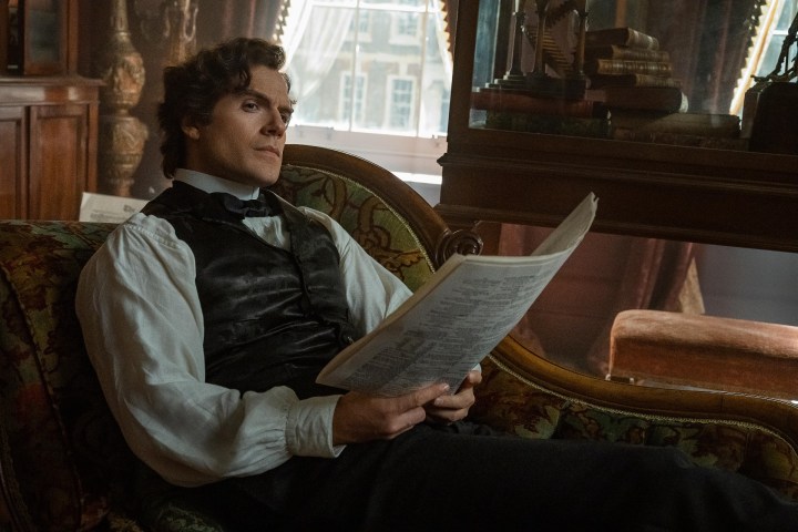 Henry Cavill sat down as Sherlock Holmes in a scene from Enola Holmes 2.