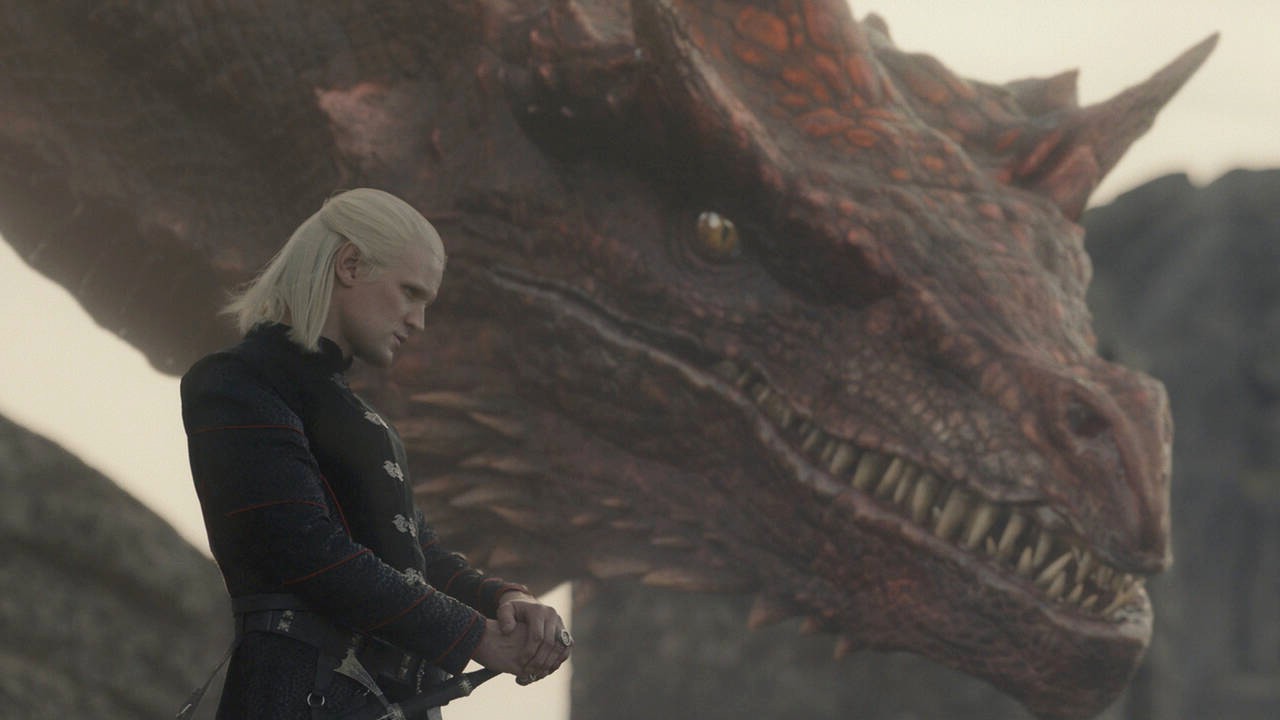 हाउस ऑफ द ड्रैगन में डेमन अपने ड्रैगन के बगल में खड़ा है।