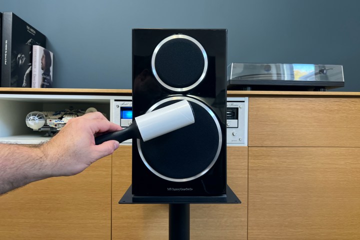 A lint roller cleaning speaker grille.