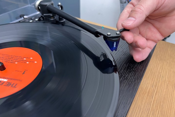 Placing the needle over the record.