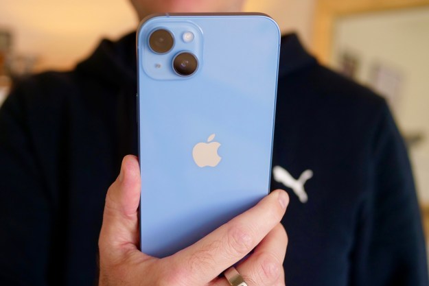 The iPhone 14 Plus held in a man's hand.