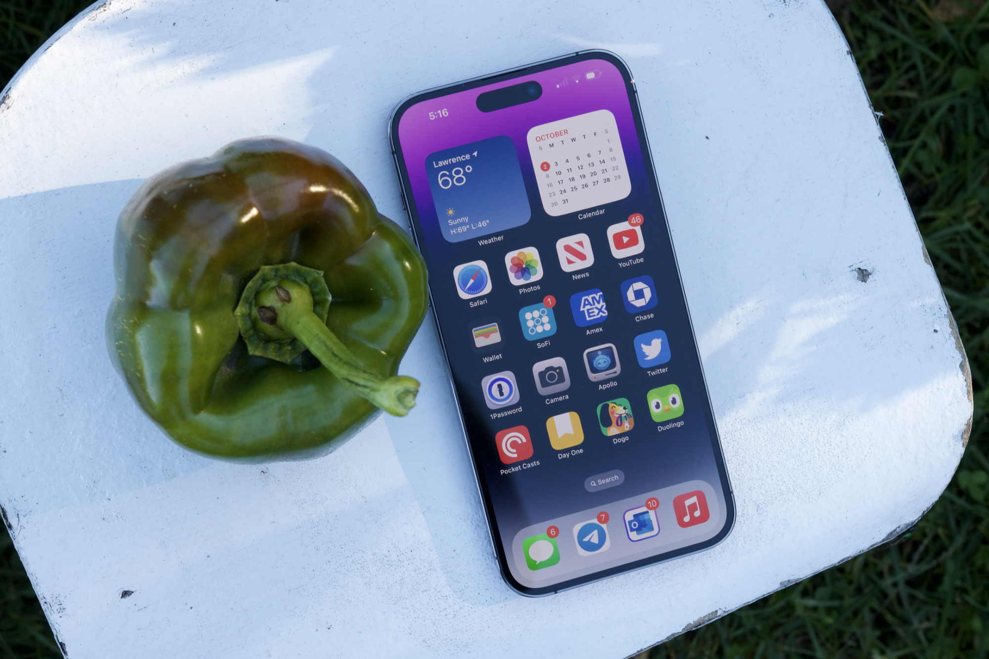 O iPhone 14 Pro Max ao lado de um pimentão verde.