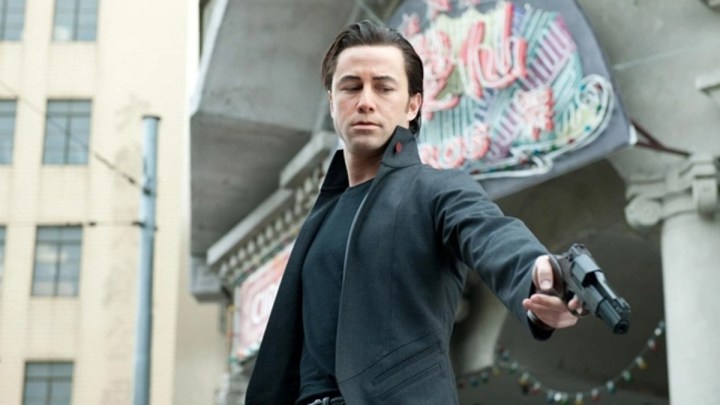 A man aims his gun to the ground in Looper.