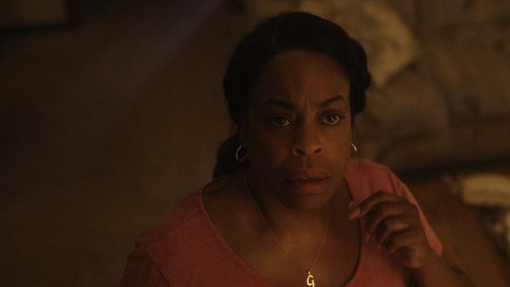 Niecy Nash as Glenda Cleveland looking up at her vent in a scene from Monster: The Jeffrey Dahmer Story.