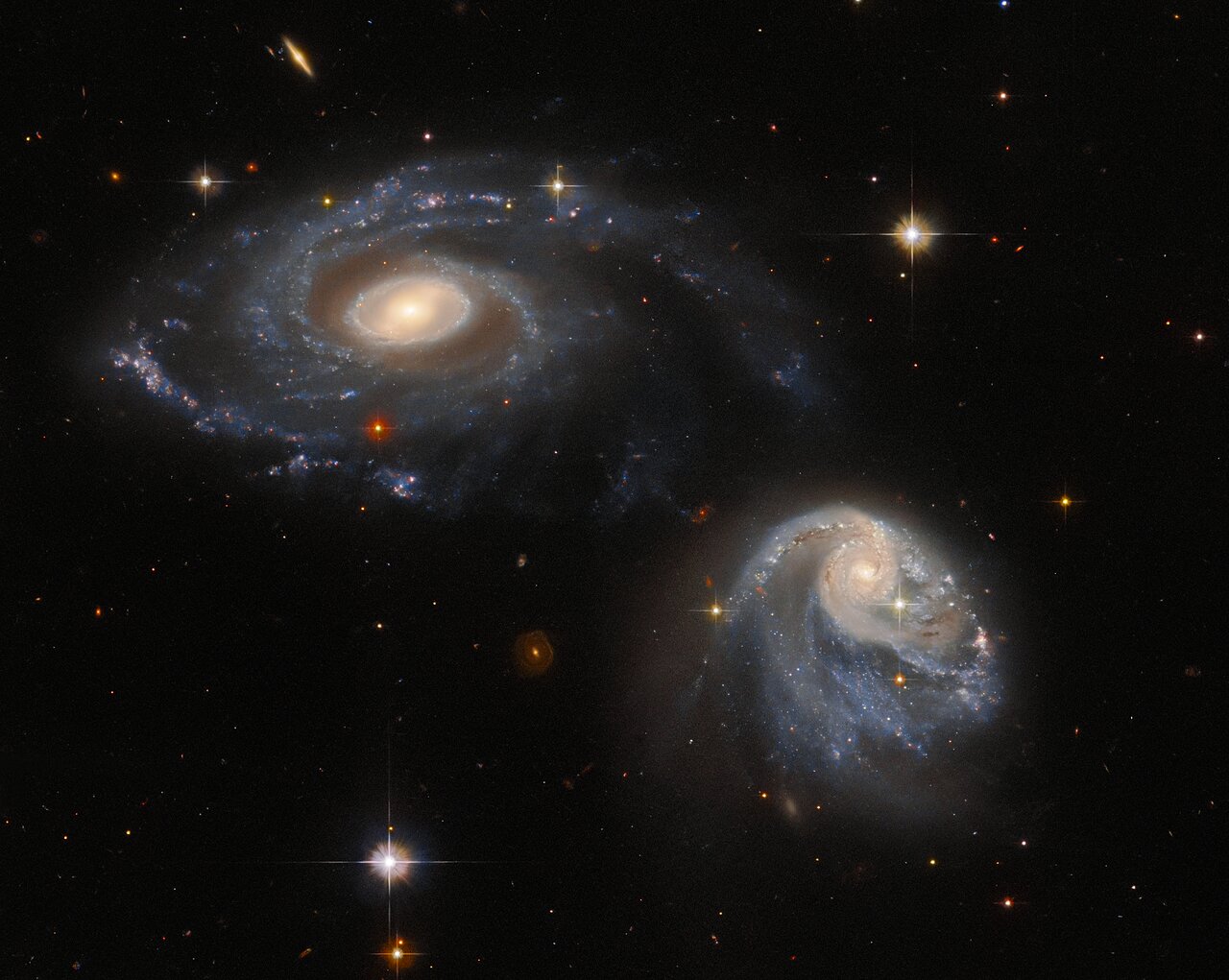 Two interacting galaxies warped by gravity in Hubble image