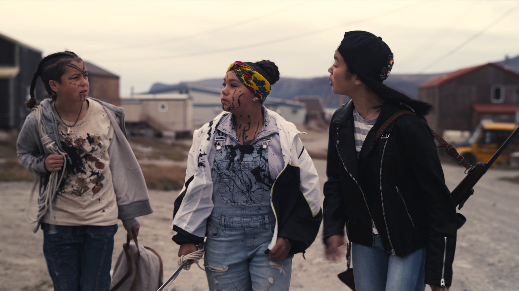 Três adolescentes brigam enquanto caminham por uma rua em uma cena de Slash/Back.