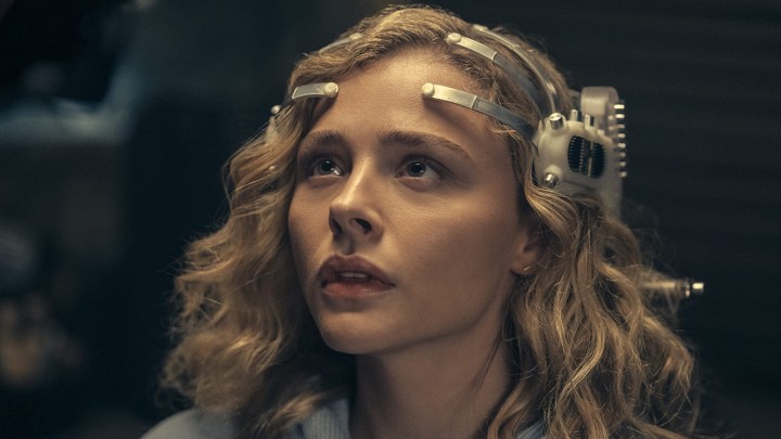 Chloe Grace Moretz wearing a futuristic gaming headset in a scene from The Peripheral on Amazon Prime.