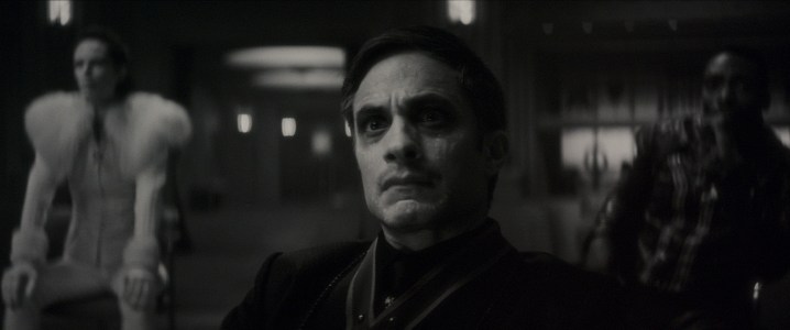 Gael García Bernal stares at a black and white scene from Werewolf By Night.
