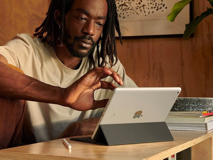 Een man werkt in zijn kantoor aan de Apple iPad uit 2021.