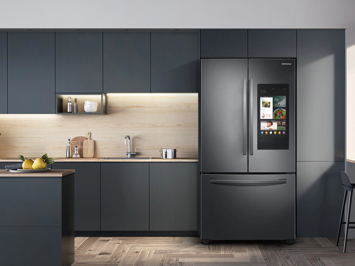 28 cu.  ft. Frigorífico Samsung 3 portas French Door com Family Hub em uma cozinha com armários cinza escuro e piso de madeira.