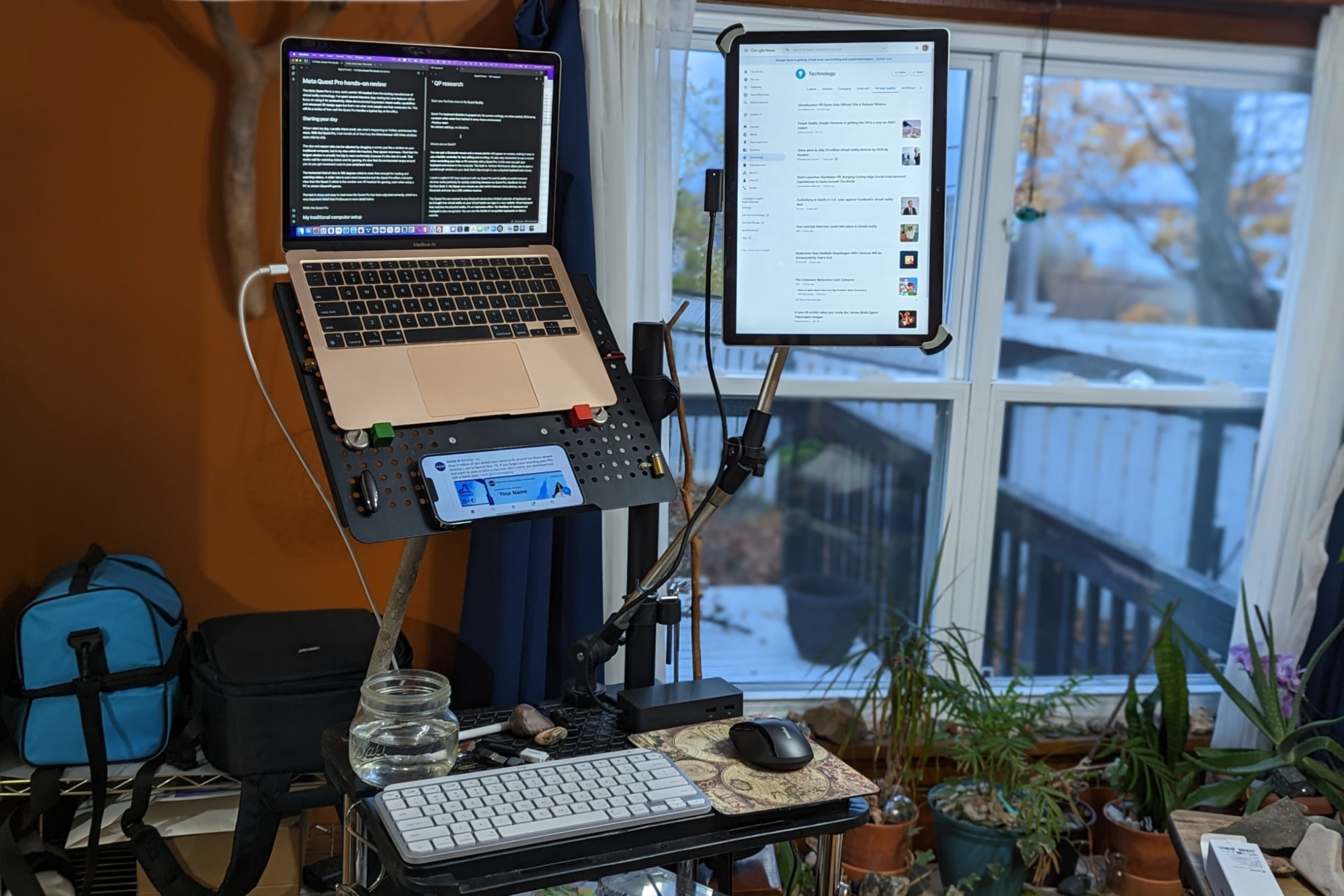El escritorio de pie de Alan Truly tiene una MacBook Air, una Surface Book 2 y un iPhone 13 Pro Max.