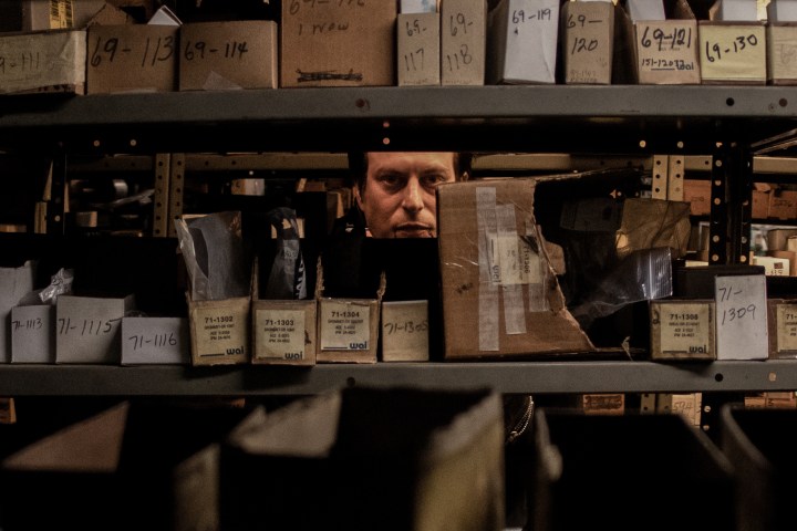 A man stares through a shelf in a scene from Blood Relatives.