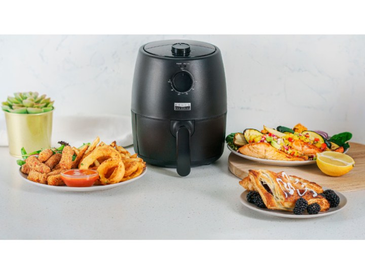 Bella Pro Series 2-quart Analog Air Fryer with sample dishes and appetizers.