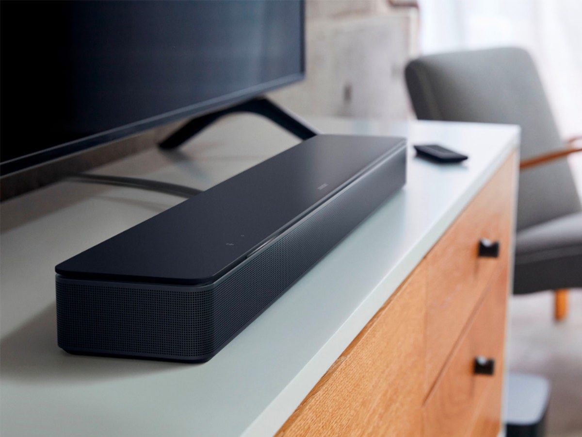 Bose Smart Soundbar 300 روی یک پایه سرگرمی زیر تلویزیون تنظیم می شود.
