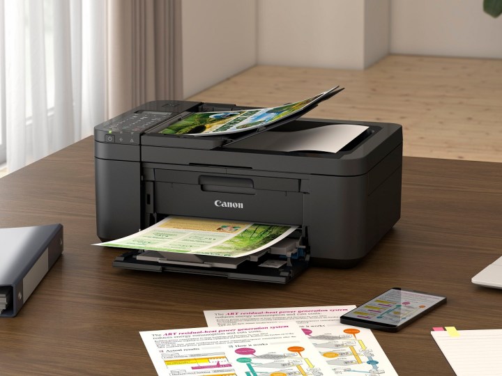 The Canon PIXMA TR4720 wireless all-in-one inkjet printer on a desk, printing pages.
