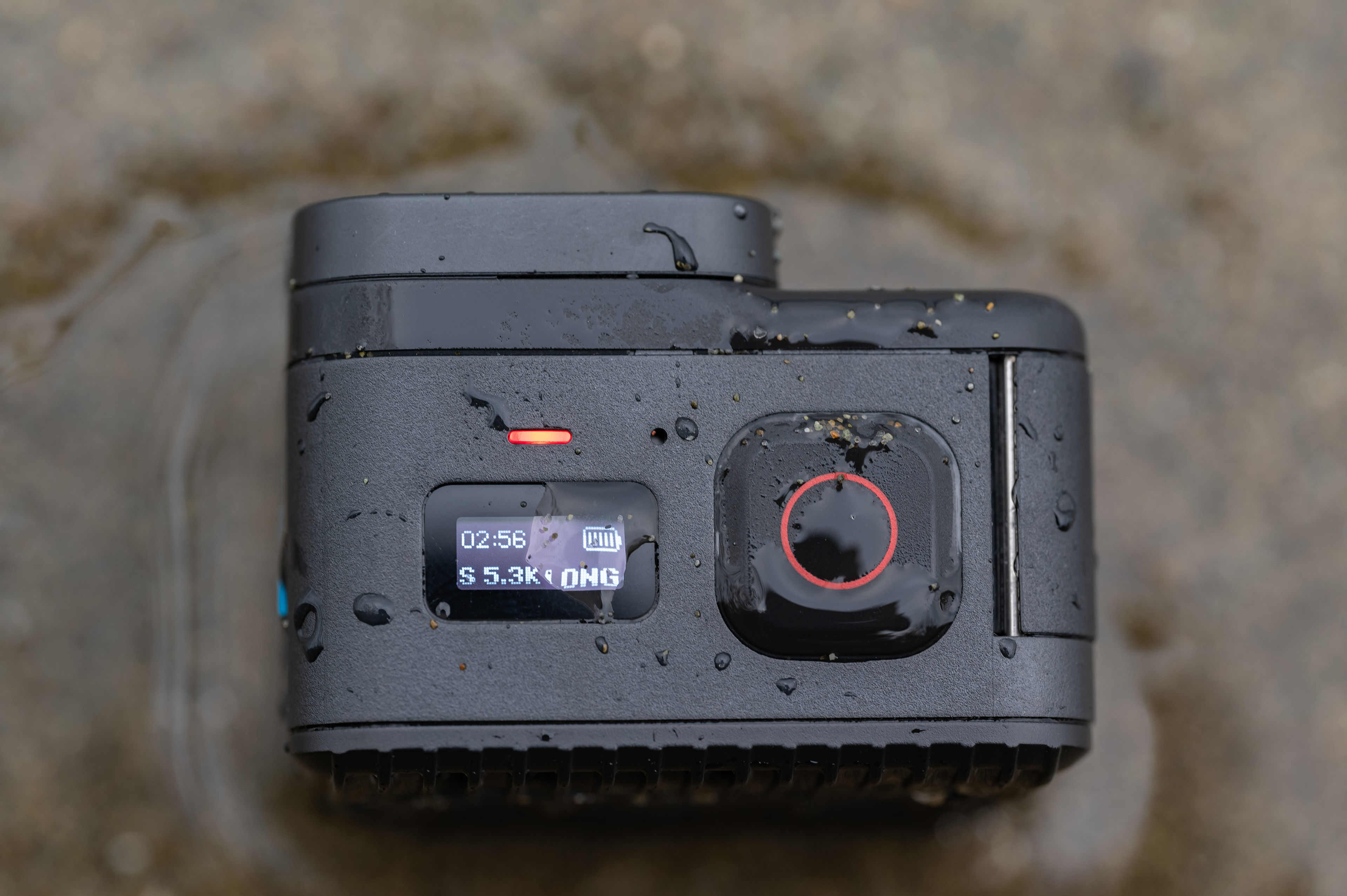 A GoPro Hero 11 Mini vista superior com areia e água.