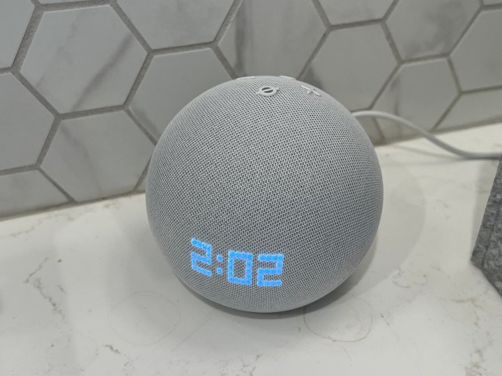 Echo Dot with clock on white countertop.