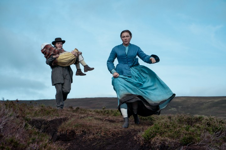 Florence Pugh walks ahead of Tom Burke and Kíla Lord Cassidy in The Wonder.
