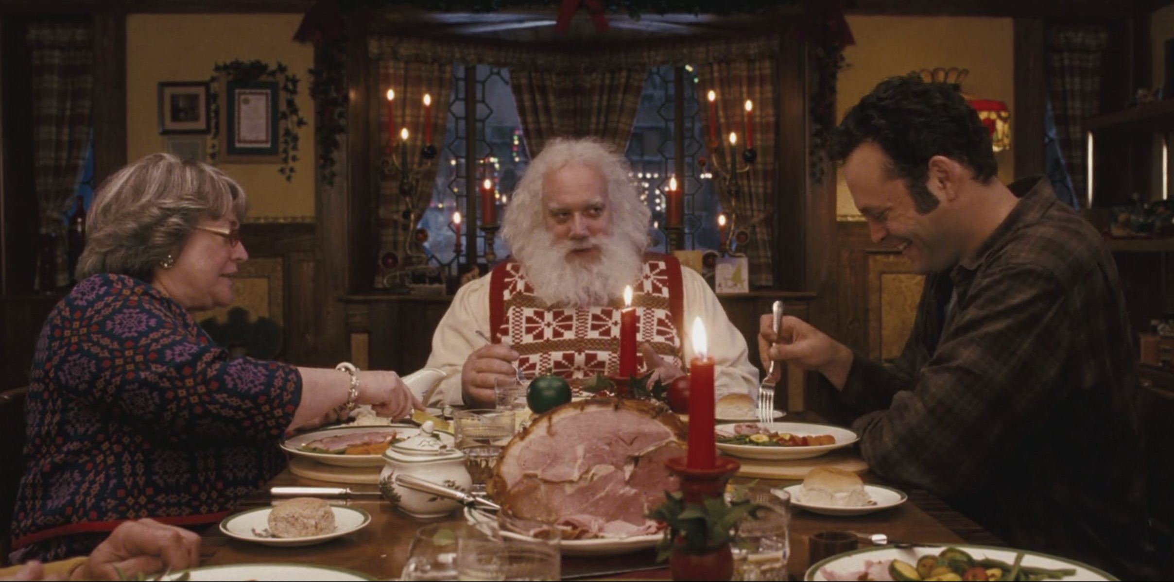 Tres personas se sientan a cenar en una escena de Fred Claus.