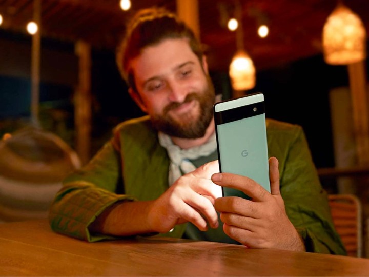A man takes a selfie with his Google Pixel 6a.
