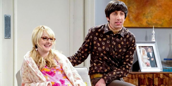 Howard senta ao lado de sua esposa grávida, Bernadette, em The Big Bang Theory