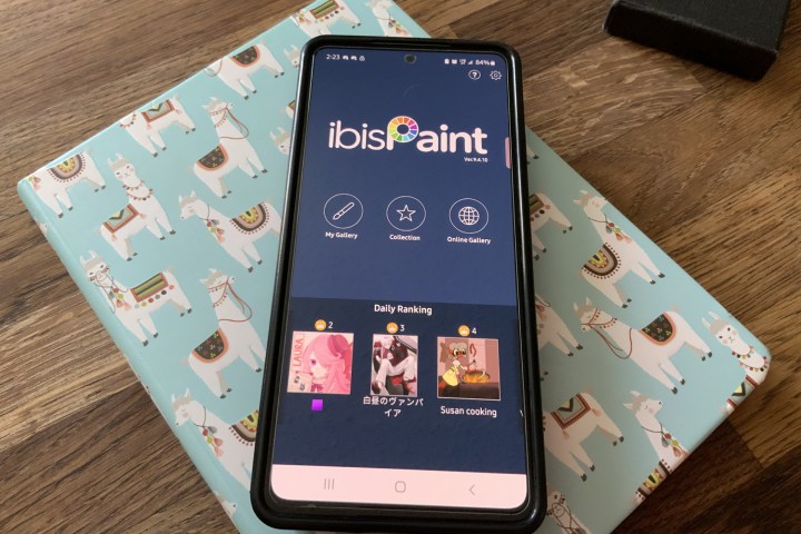 The phone displays the ibisPaint technical program on the screen.